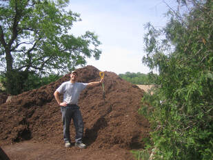 Picture of a guy in front of a mulch pile.